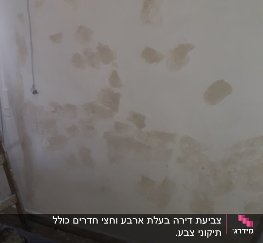 קיר עם תיקוני טיח, סולם ודלי צבע